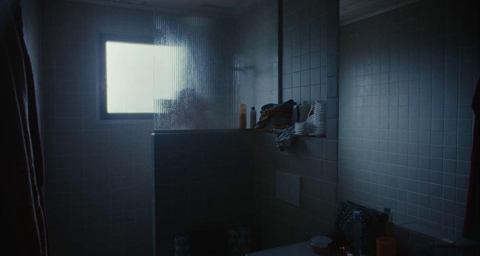 a dark bathroom with a window and a sink