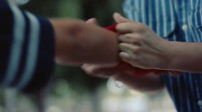 a close up of two people holding hands