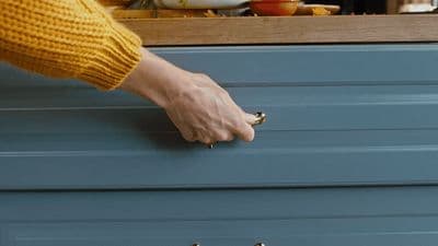 a person's hand reaching into a drawer