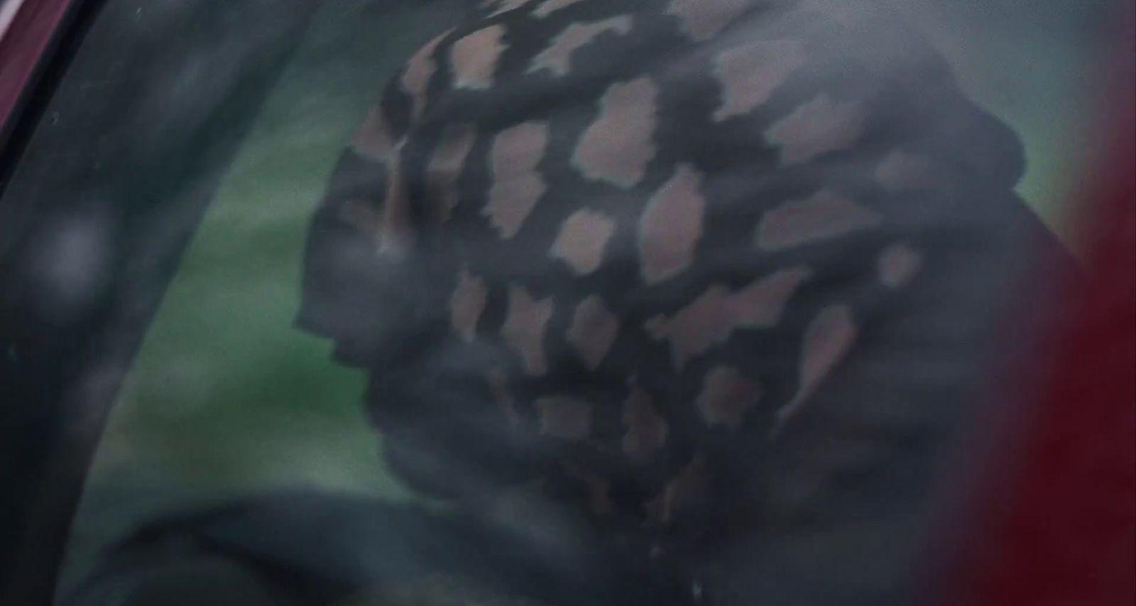 the reflection of a man in the window of a car