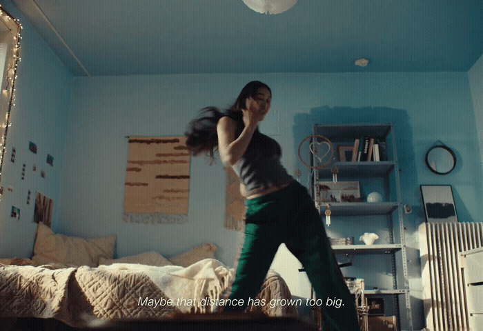 a woman standing on a bed in a room