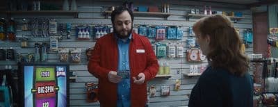 a man standing in front of a store talking to a woman