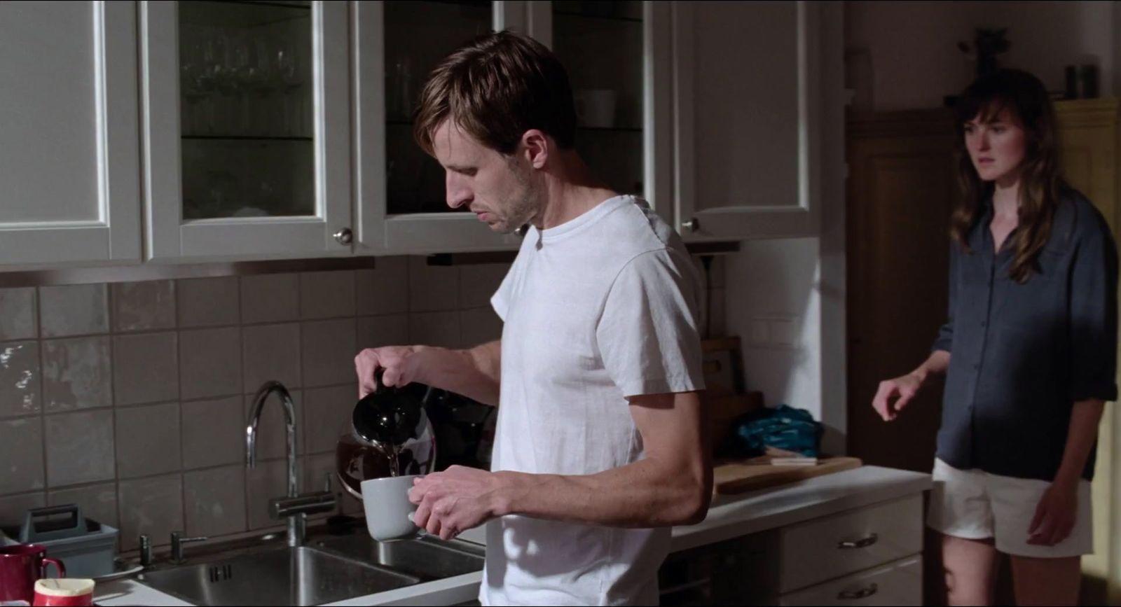 a man and a woman standing in a kitchen