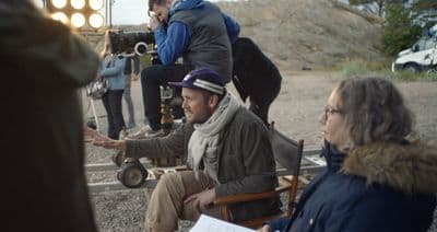 a man sitting in a chair talking to a woman