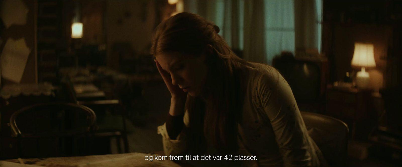 a woman sitting at a table with her head in her hands