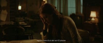 a woman sitting at a table with her head in her hands