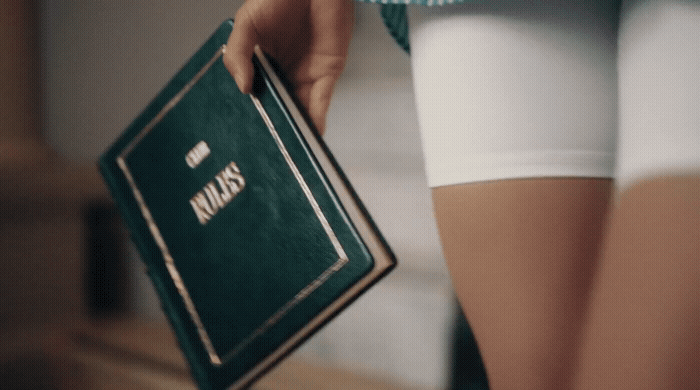 a woman in white shorts holding a green book