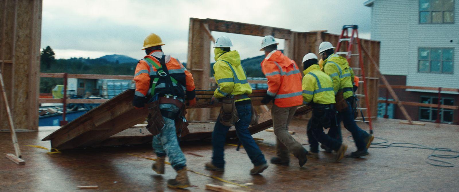 a group of construction workers working on a building