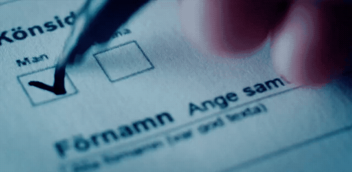 a person filling out a form with a pen