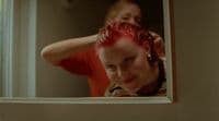a woman is brushing her hair in front of a mirror