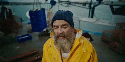a man with a beard wearing a yellow jacket