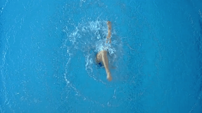 a person is swimming in a pool with blue water