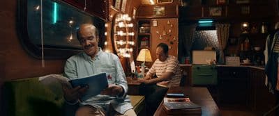 a man sitting in a train car reading a paper