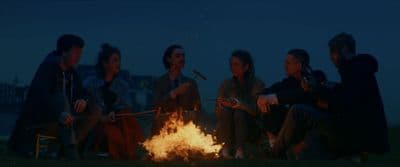 a group of people sitting around a fire