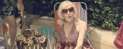 an older woman sitting in a lawn chair