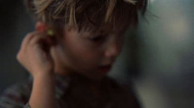 a young boy holding a cell phone to his ear