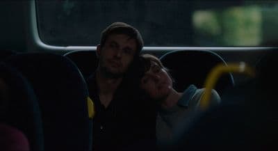 a man and a woman sitting on a bus