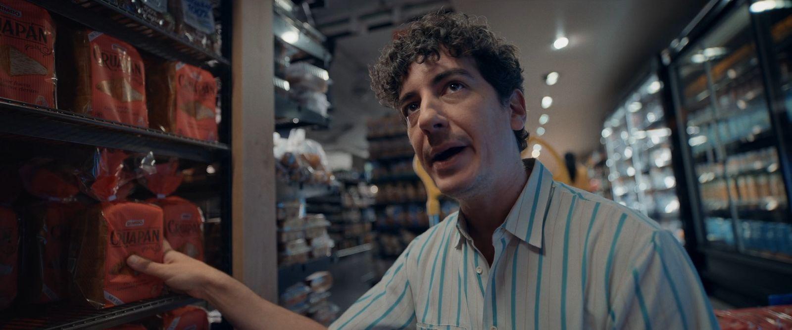 a man in a store looking at a shelf of sodas