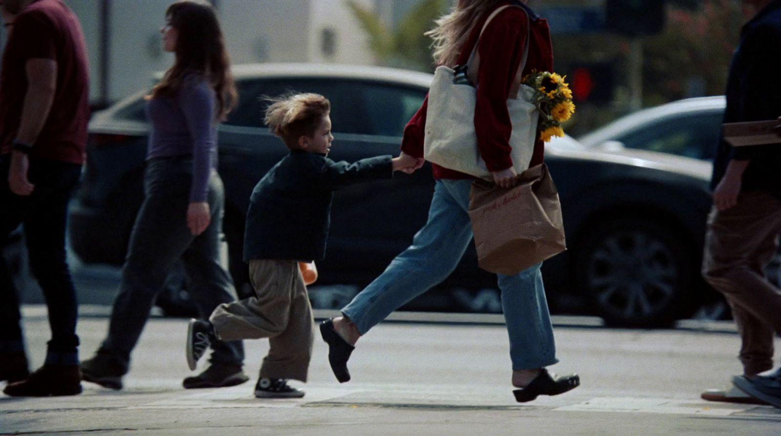 a woman walking down a street with a child