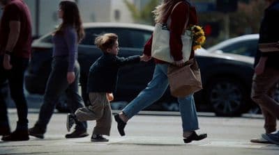 a woman walking down a street with a child