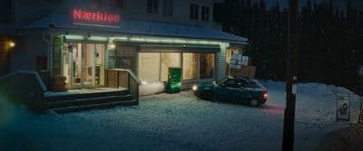 a car parked in front of a building in the snow