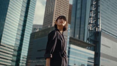 a woman standing in front of tall buildings