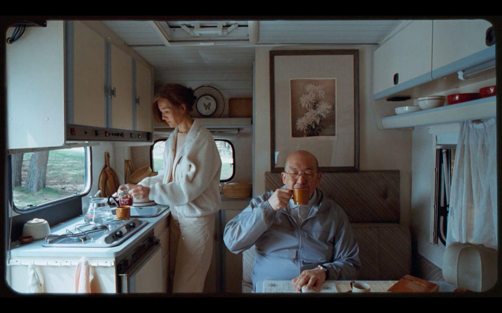 a man and a woman sitting in a kitchen next to each other