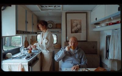 a man and a woman sitting in a kitchen next to each other