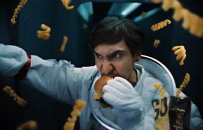 a man in a space suit eating a hot dog