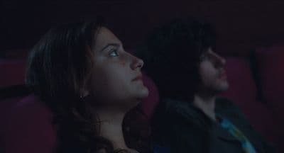 a man and a woman sitting in a movie theater