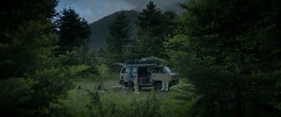a van parked in the middle of a forest