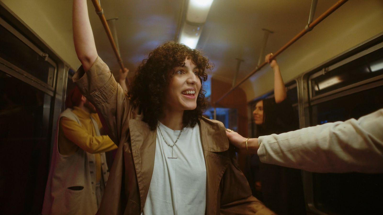 a woman standing on a train with her arms in the air
