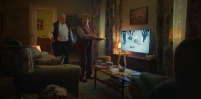 a couple of people standing in a living room