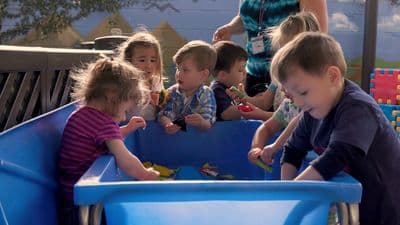 a group of children playing in a blue toy pool