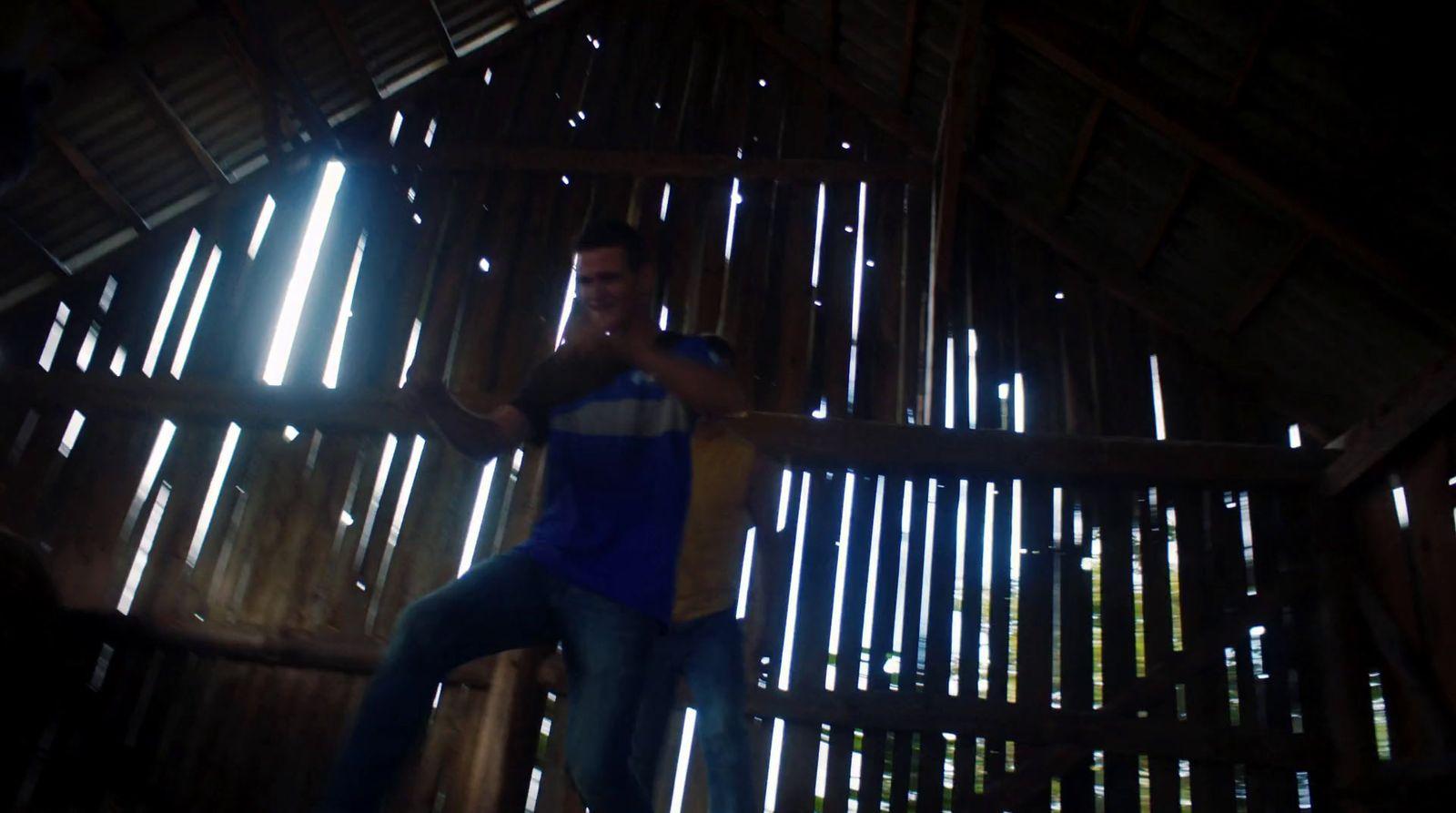 a man in a blue shirt standing in a room