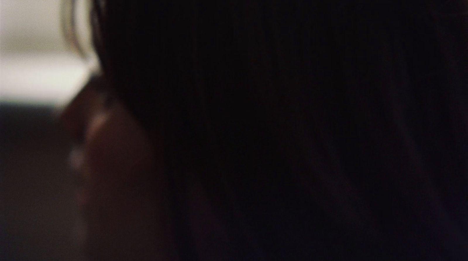 a close up of a woman's face with a cell phone in her hand