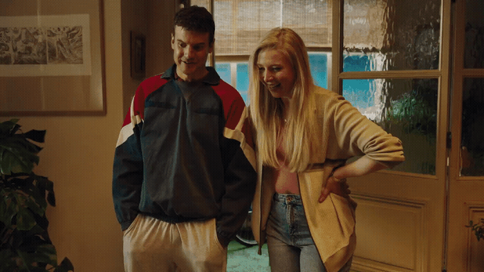 a man standing next to a woman in a living room