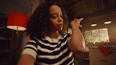 a woman in a striped shirt smoking a cigarette