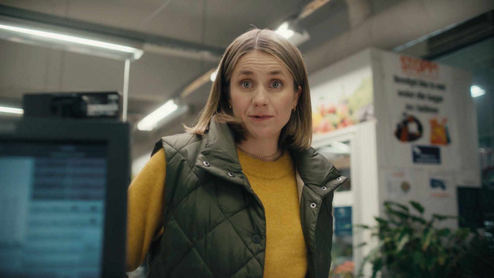 a woman standing in a room with a microwave