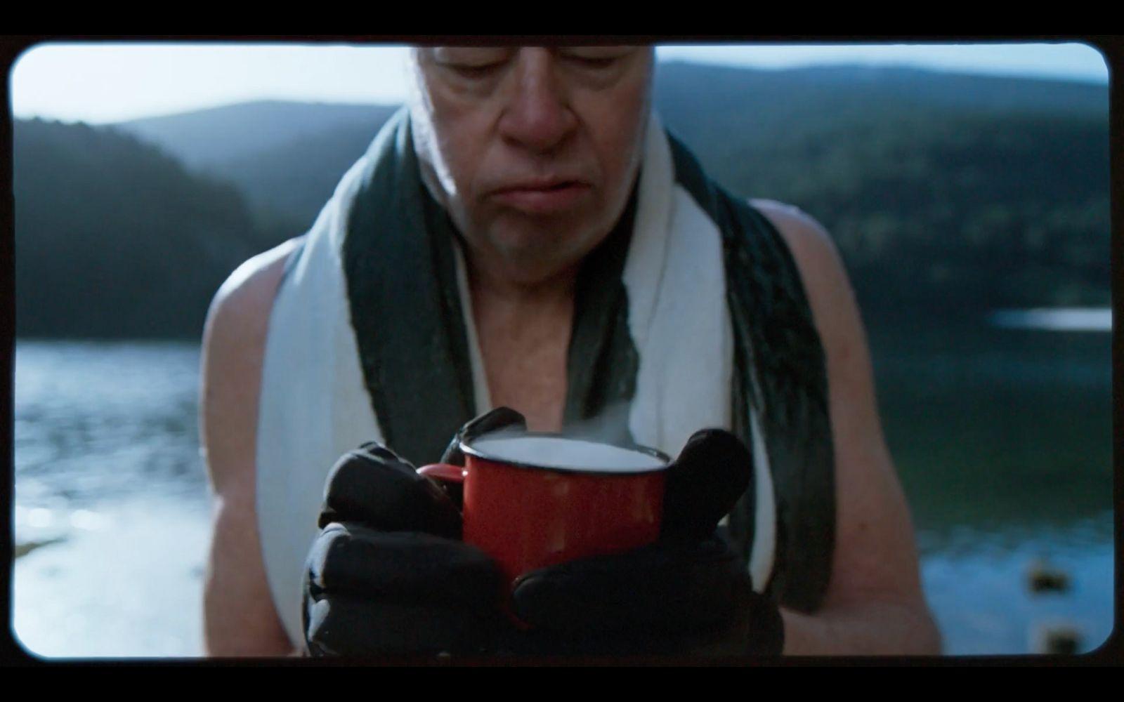 a man holding a cup of coffee in his hands
