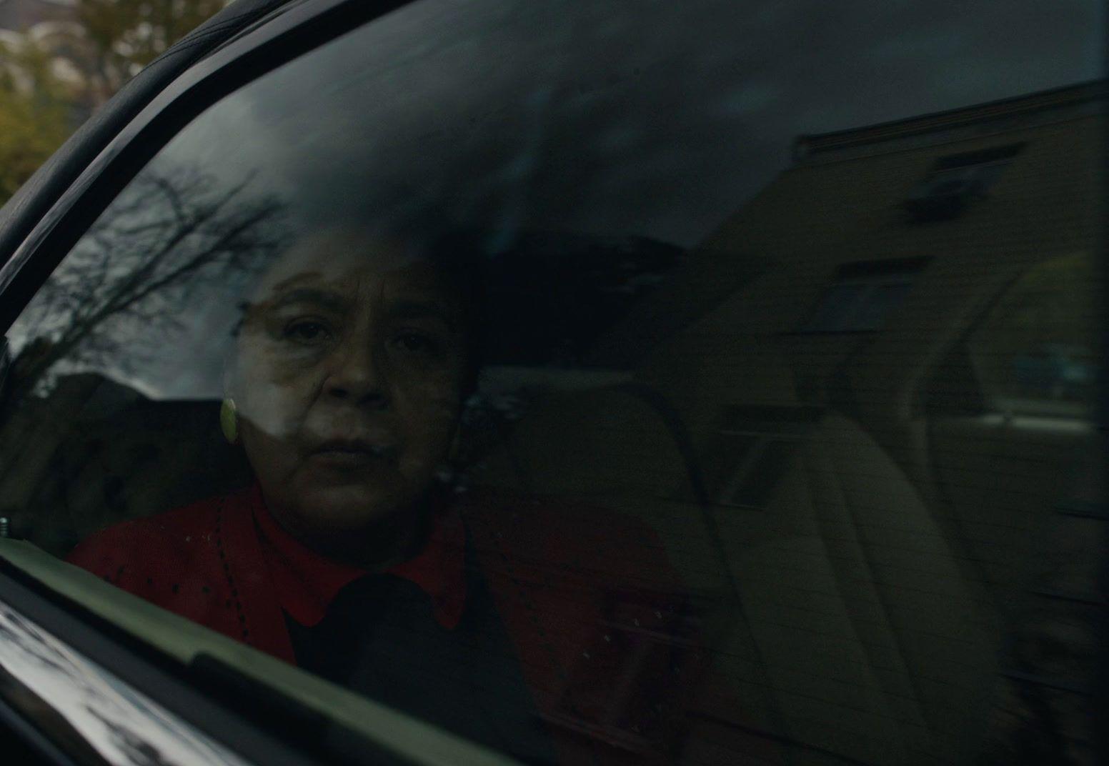 a woman sitting in a car looking out the window