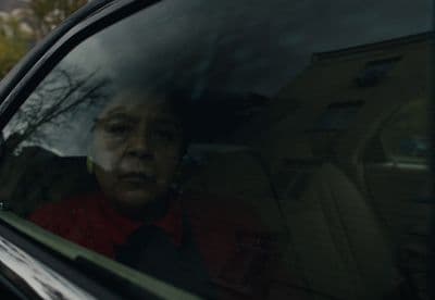 a woman sitting in a car looking out the window