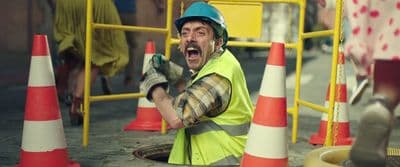 a man in a safety vest and hard hat holding a wrench