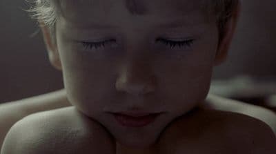 a close up of a child with closed eyes