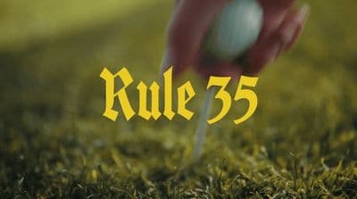 a golf ball being put into a tee