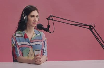 a woman wearing headphones sitting in front of a microphone