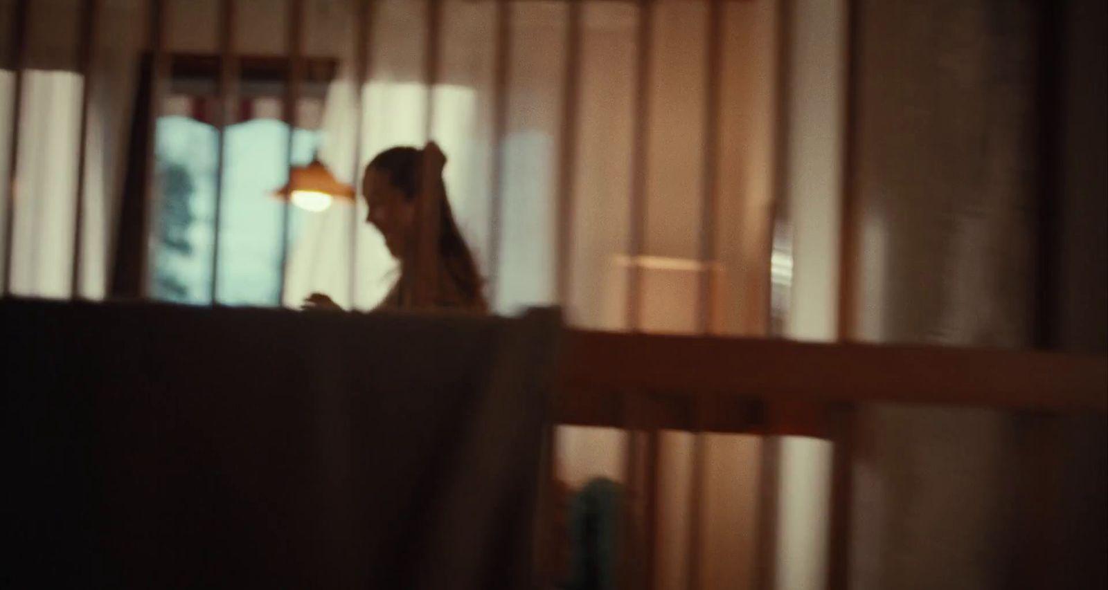 a woman standing in a room next to a window
