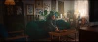 a woman sitting on a green couch in a living room