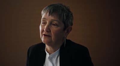 a woman in a black jacket and white shirt