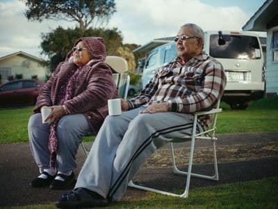 a man and a woman sitting on a lawn chair